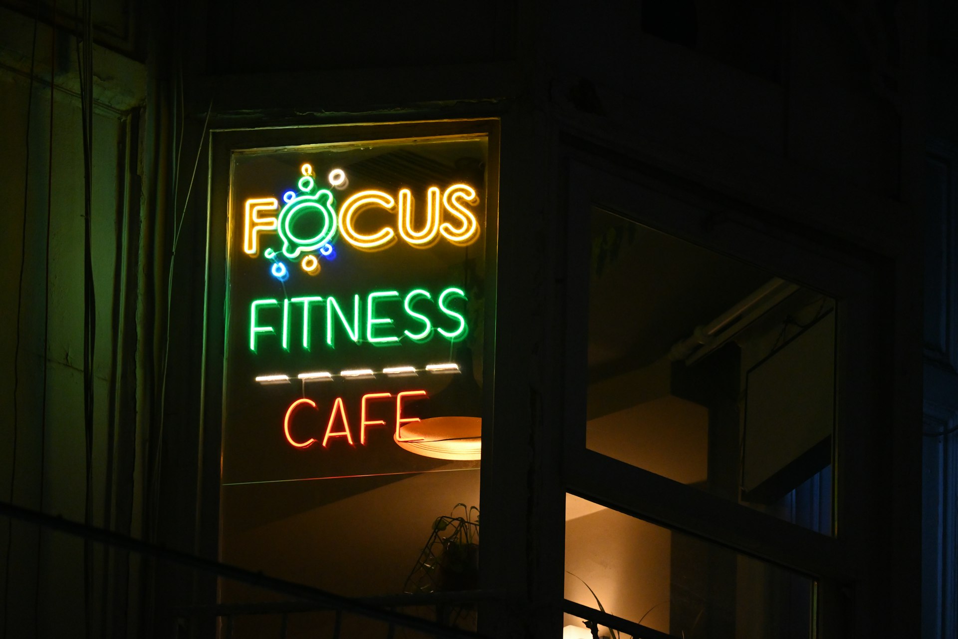 A focus fitness cafe sign lit up at night